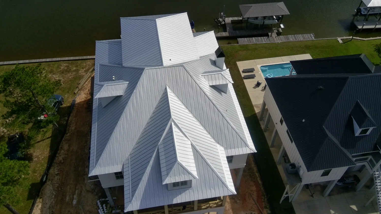 Coastal home featuring a bright metal roof, photographed from above
